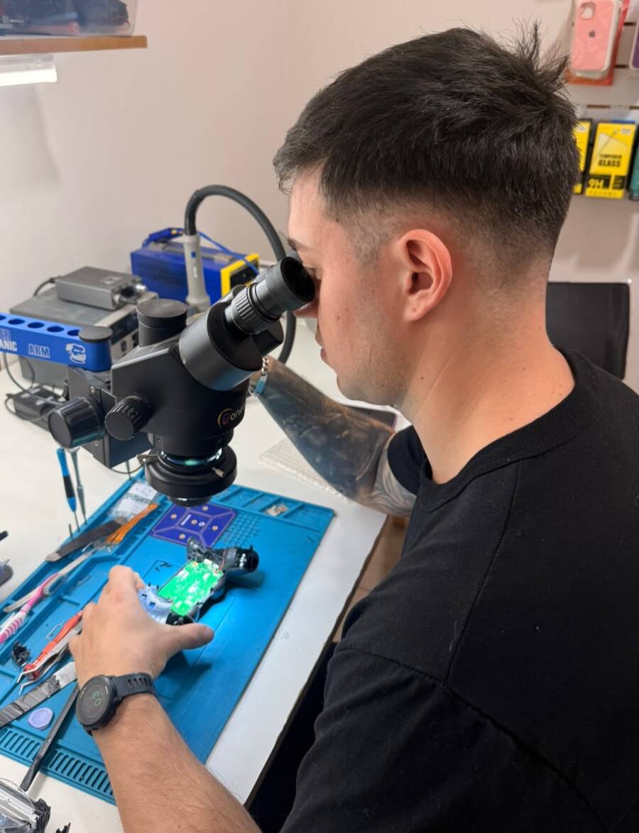 Andrés, técnico de Onetech, reparando una placa con microscopio